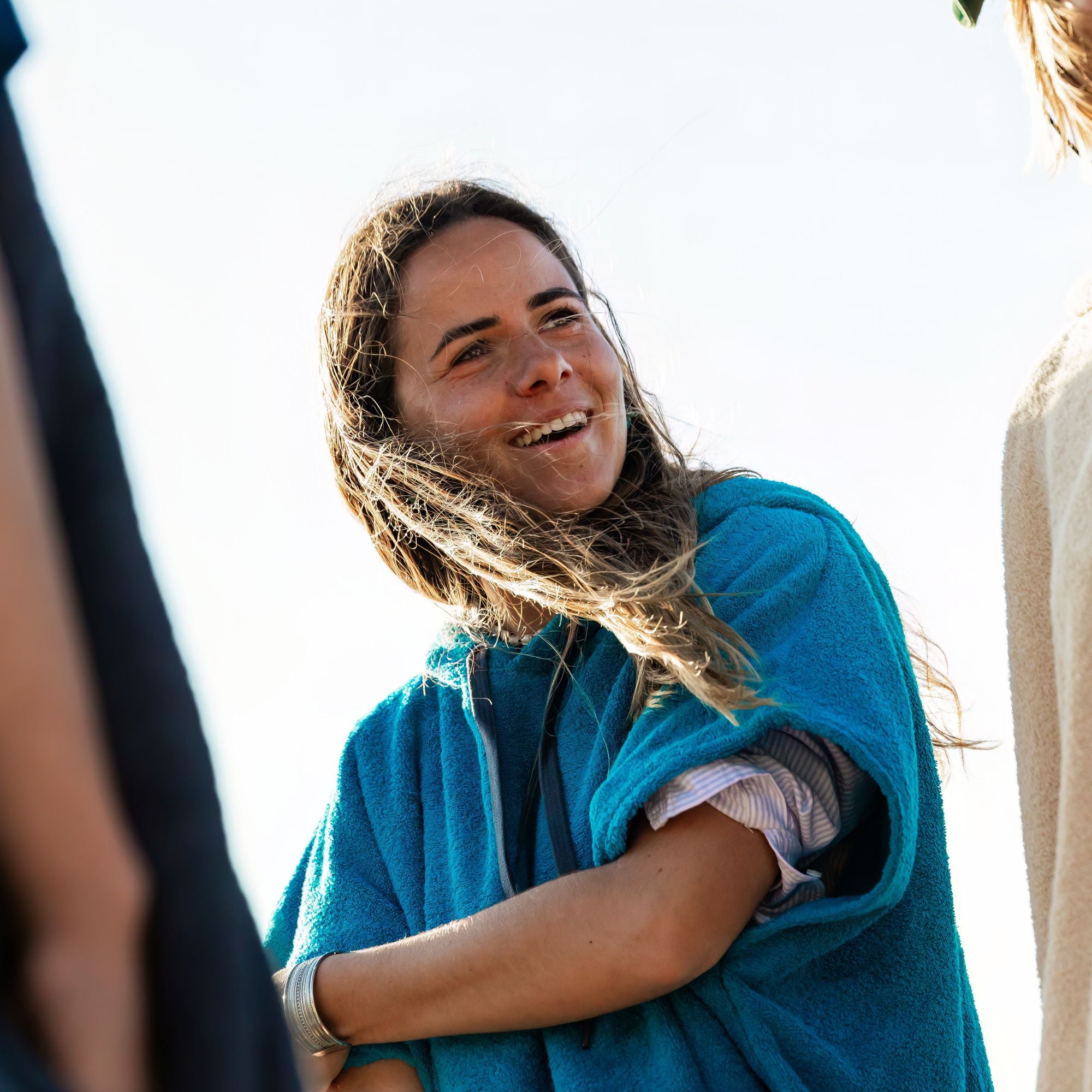 a woman wrapped in a blue towel smiling