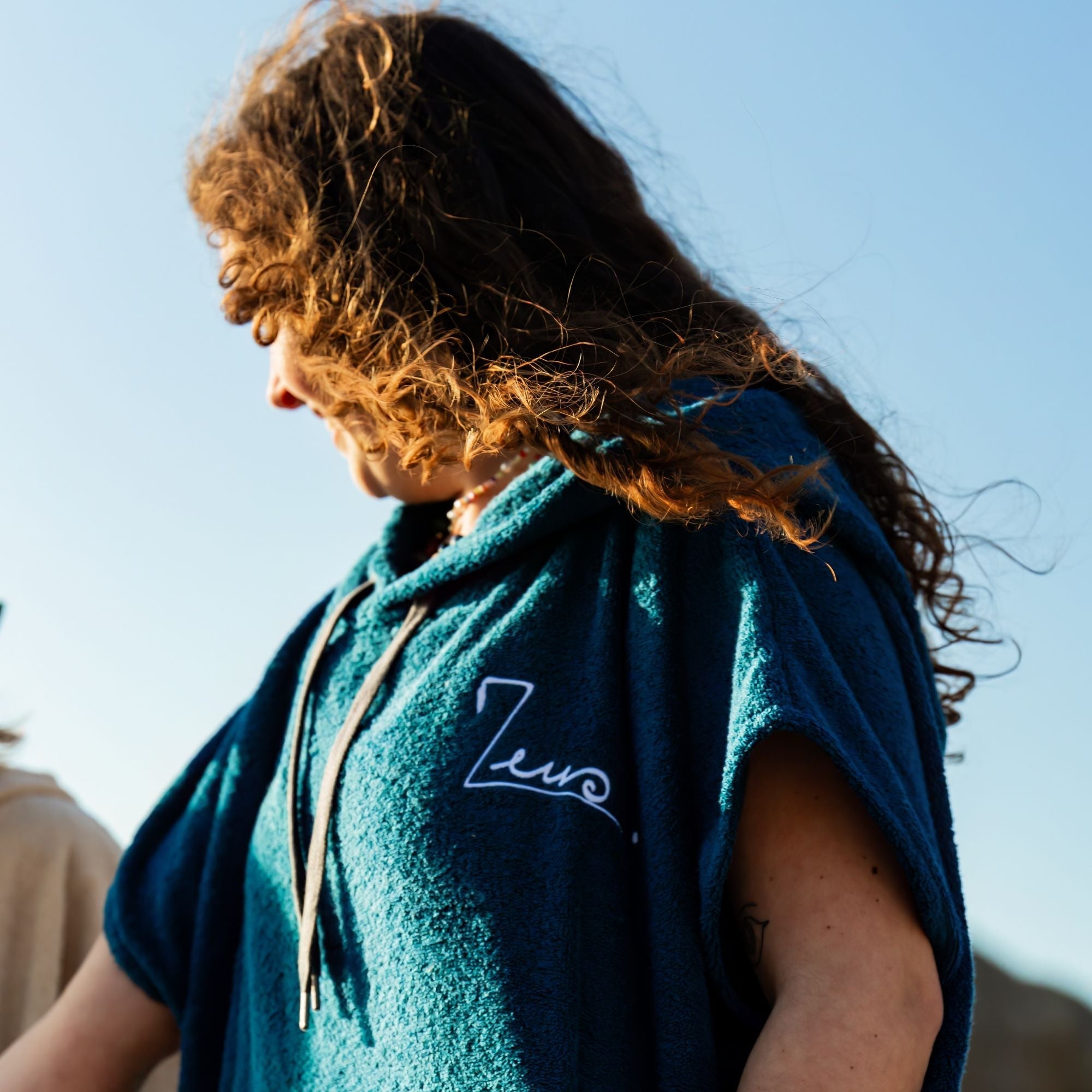 a woman with long hair wearing a blue hoodie