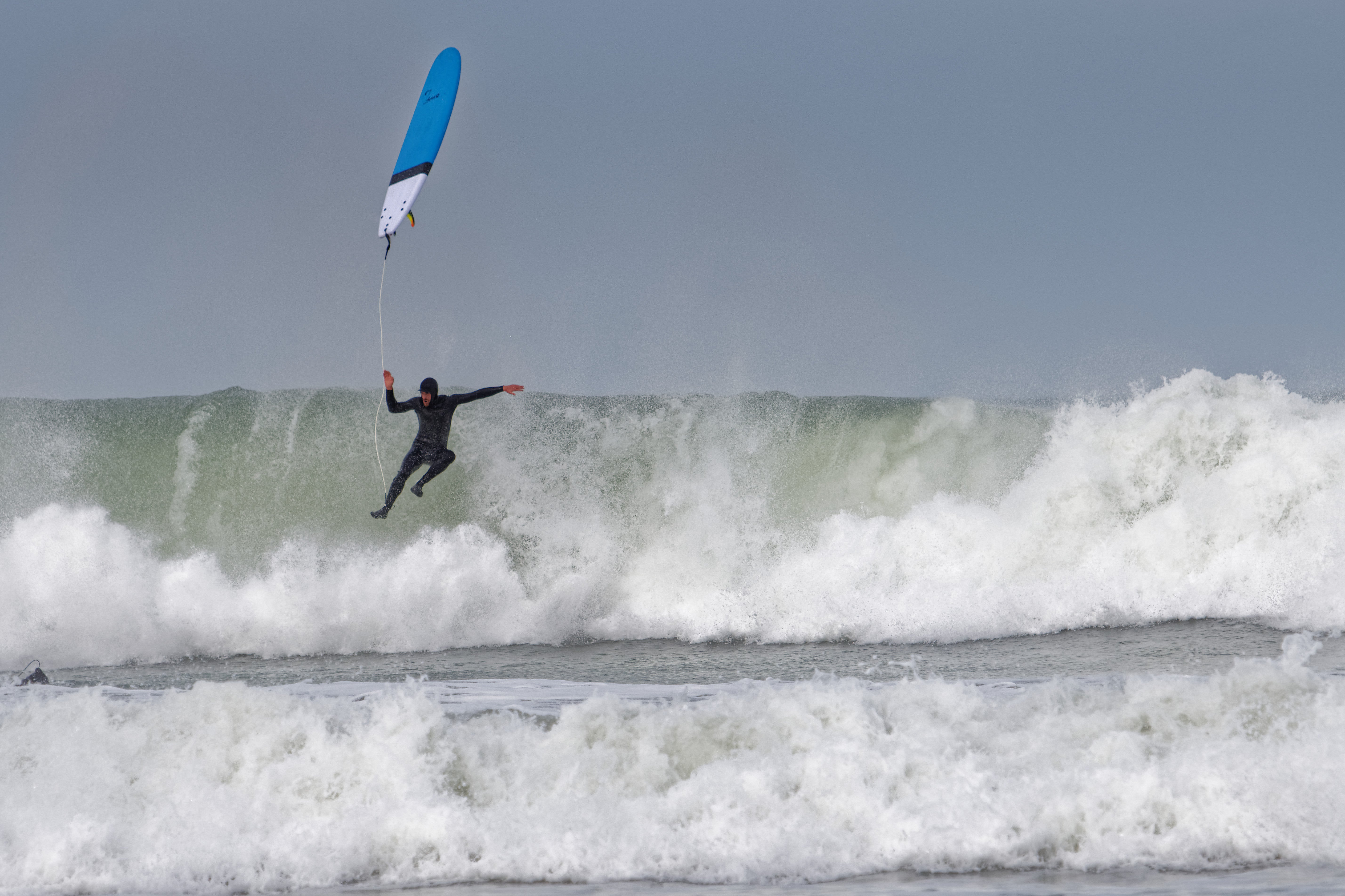 a man riding a surfboard on top of a wave