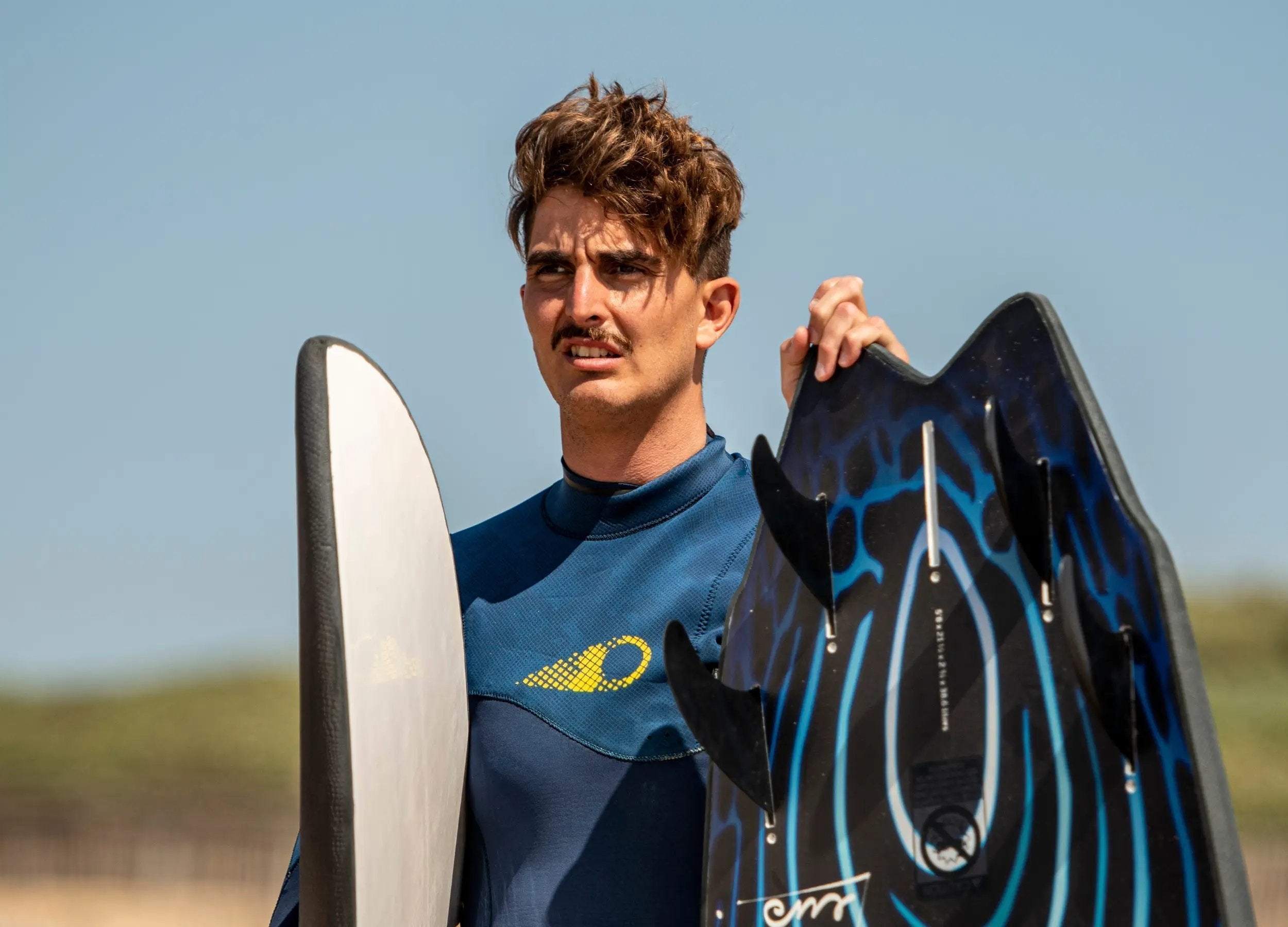 a man holding a surfboard on a beach