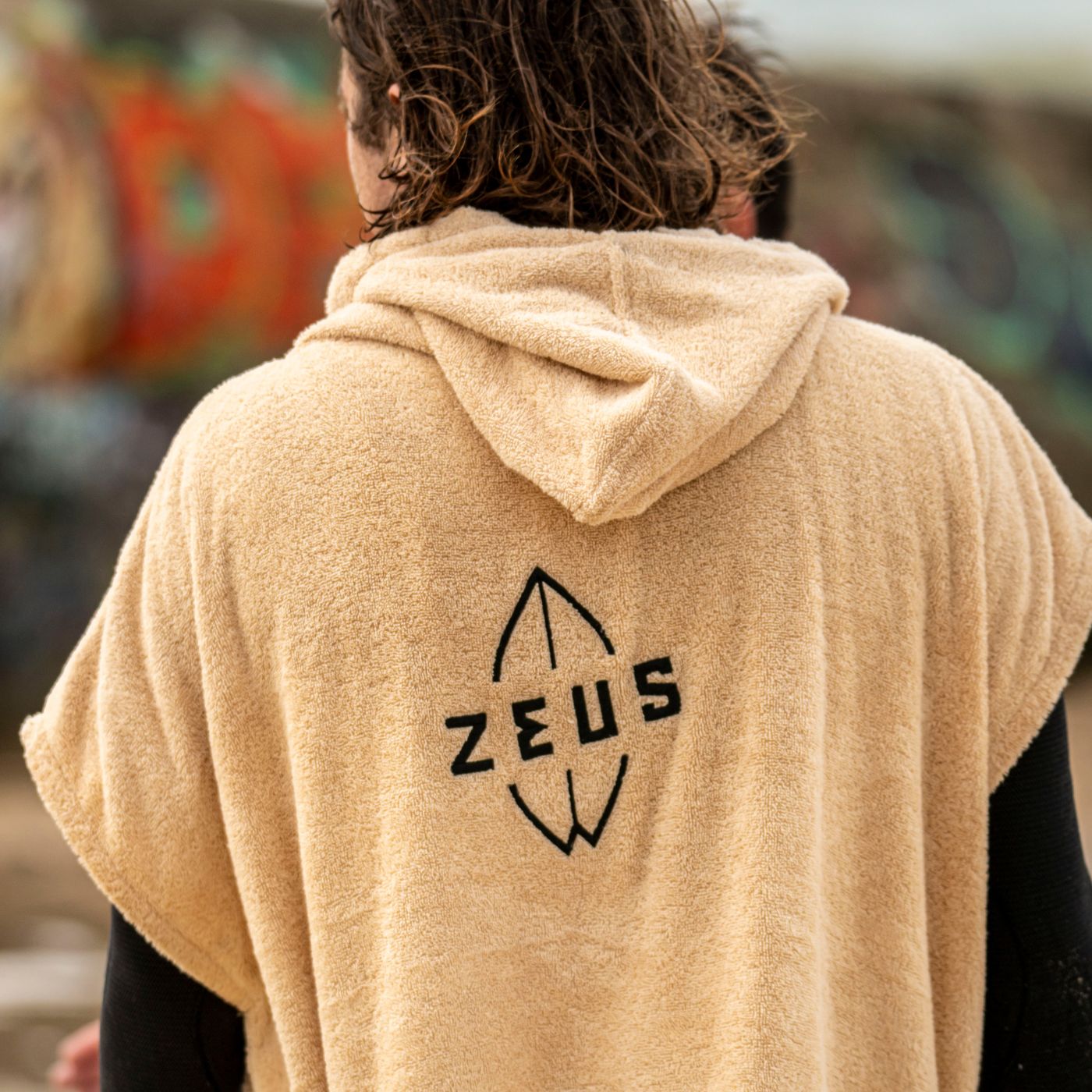 a person wearing a hooded sweatshirt with the word zeus on it