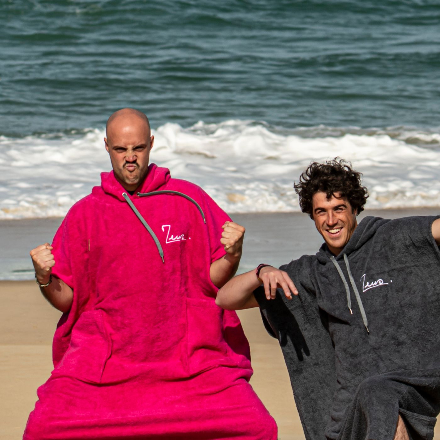 a couple of men standing next to each other on a beach